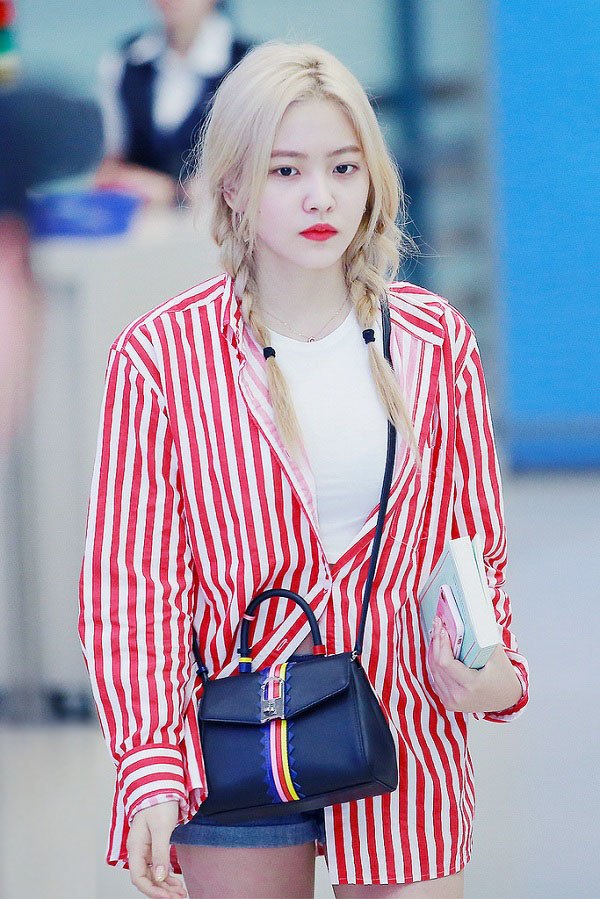 Yeri (Red Velvet) mix áo sơ mi oversized sọc đỏ với quần short và áo thun trắng. Cách phối này đem đến sự trẻ trung, năng động.