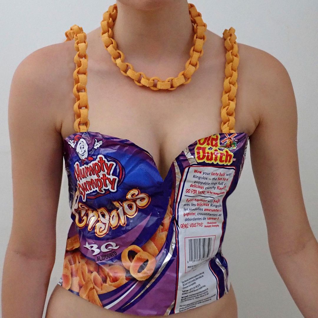 Chiếc áo corset cá tính bằng vỏ vứt đi của gói snack. Thiết kế này còn cực kỳ thuyết phục khi sử dụng chính những chiếc bánh snack hình vòng mắc xích thành dây áo, vòng cổ.