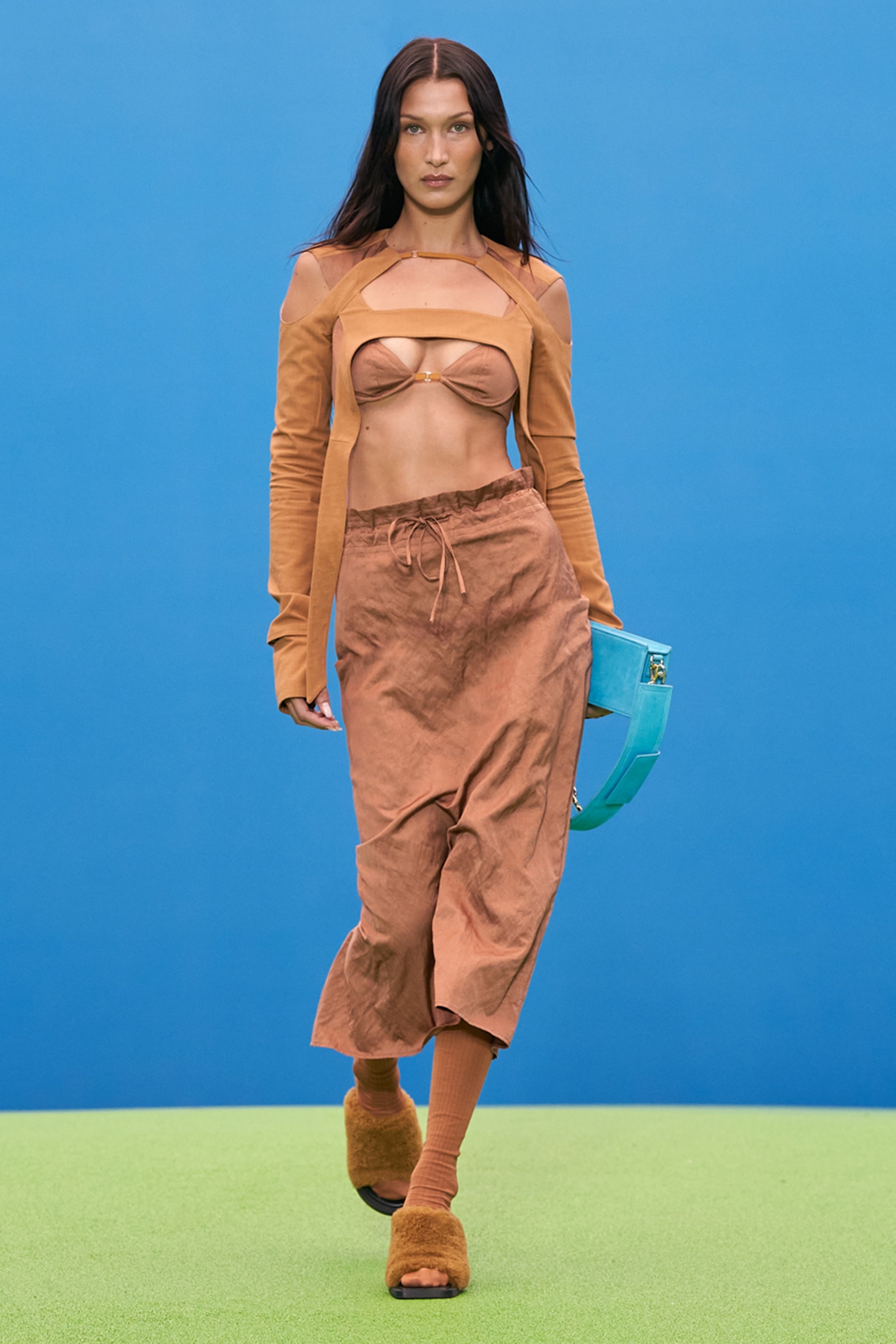 Bella Hadid trong thiết kế áo croptop phối cùng nội y, những đường cắt xẻ táo bạo, khoe vòng eo săn chắc, quyến rũ. Gam nâu trung tính làm nổi bật vẻ đẹp làn da của nữ người mẫu.