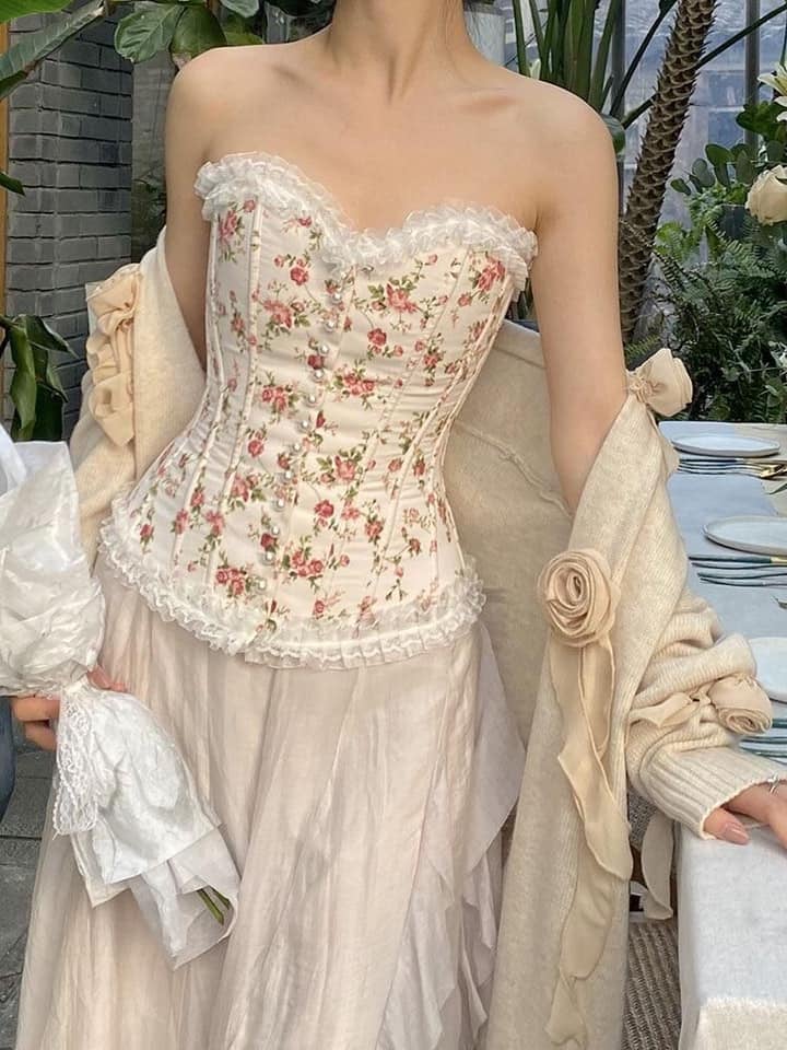 Vintage corset với chất liệu ren kết hợp với hoạ tiết hoa lá xinh xắn luôn mang đến cảm giác thanh lịch, quyến rũ cho bất kì cô gái nào. Thay vì loại thắt dây thông thường, bạn có thể thử qua chiếc corset thắt nút ngọc trai sang trọng này.
