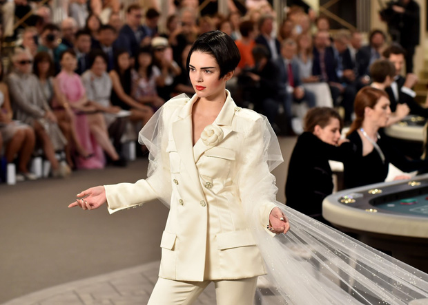 Kendall Jenner cũng từng xuất hiện trong trang phục kết màn của show Chanel năm 2015. Mái tóc Bob cá tính, bộ tuxedo thanh lịch kết hợp với vải trắng 2 bên tay mang đến hình ảnh cô dâu thời hiện đại. 