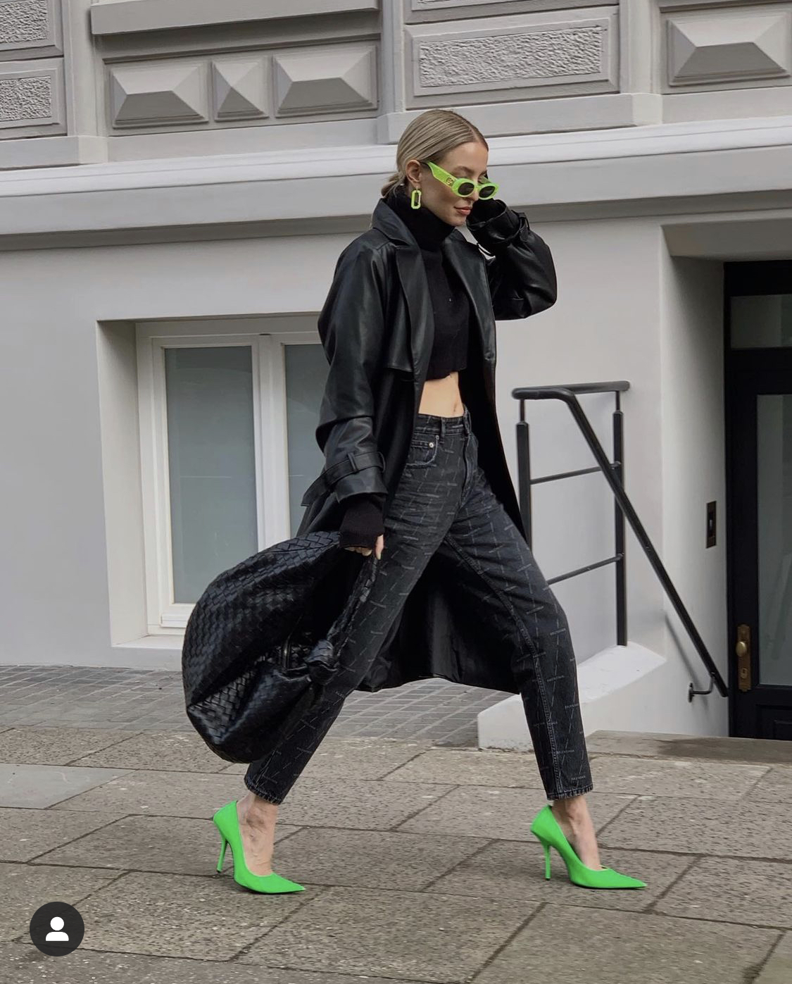 Diện cây đen từ áo croptop, trench coat đến quần, Leonie Hanne vẫn tạo sự ấn tượng với đôi cao gót lẫn kính mát màu xanh lá.