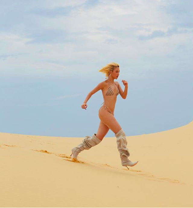 Mặc bikini “mỏng manh”, Quỳnh Anh Shyn “chạy trên đồi cát, đập tan cơn khát” với đôi boots to “khủng bố”.