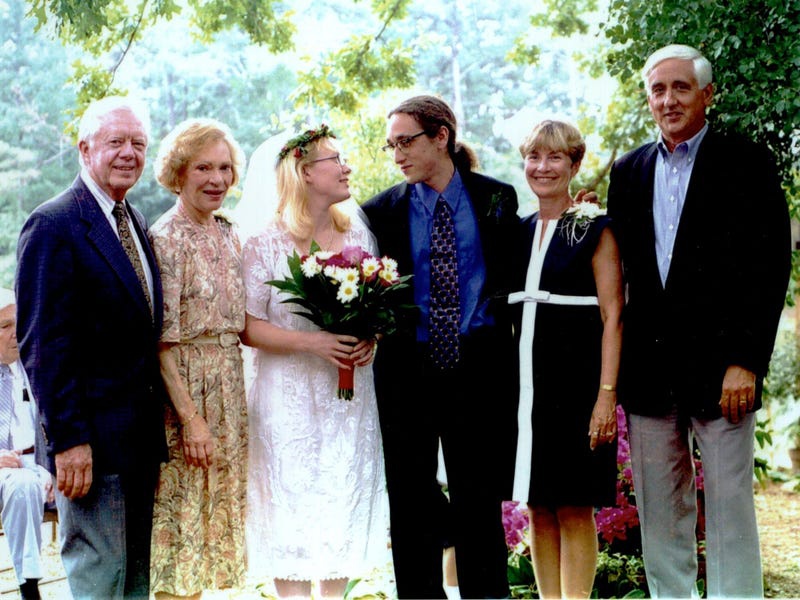 Con gái cựu tổng thống Mỹ đời thứ 39 - Jimmy Carter chọn mẫu váy cưới giản dị, có phom dáng tượng tự như mẫu váy chữ 'A' phổ biến. Amy cũng chọn hoa tươi để kết thành vòng hoa và hoa cầm tay trong lễ cưới.