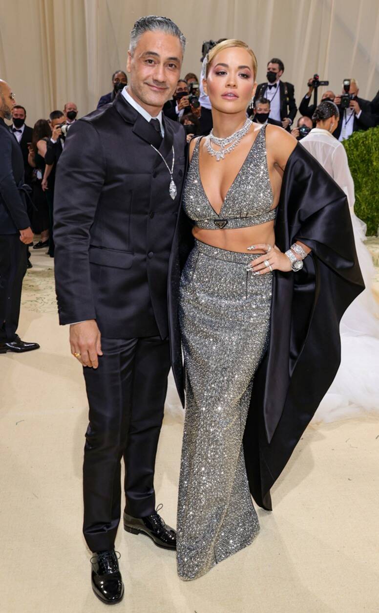 Rita Ora công khai tình cảm với bạn trai - đạo diễn Taika Waititi tại sự kiện Met Gala 2021. Cô nàng diện thiết kế sequin ánh bạc ôm body, khoác áo lụa đen đồng điệu với bộ suit của bạn trai. Họ cùng đeo trang sức kim cương để thể hiện sự liên kết.