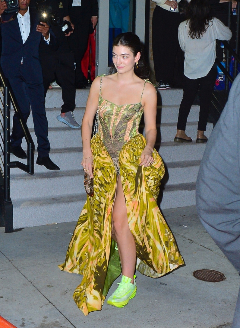 Lorde sau màn khoe vẻ đẹp xuất thần trên thảm đỏ lại phá cách với váy hai dây vàng chanh, giày sneakers neon cho dễ 'quẩy'.