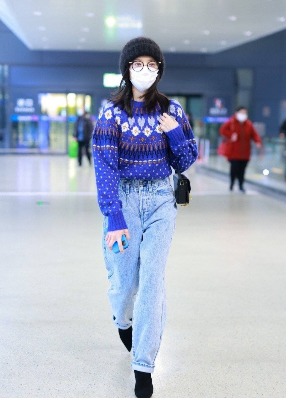Áo sweater len màu xanh hoạ tiết sơ vin với quần baggy jeans trông mát mắt, cô chọn mũ len, túi xách đến giày đều cùng một màu đen thể hiện sự tinh tế trong tư duy thời trang.