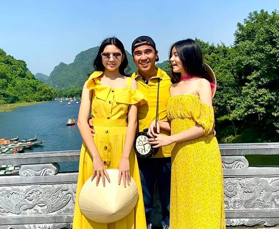 Đi du lịch, nam MC mặc polo basic màu vàng để đồng điệu với váy áo xinh của hai con gái.