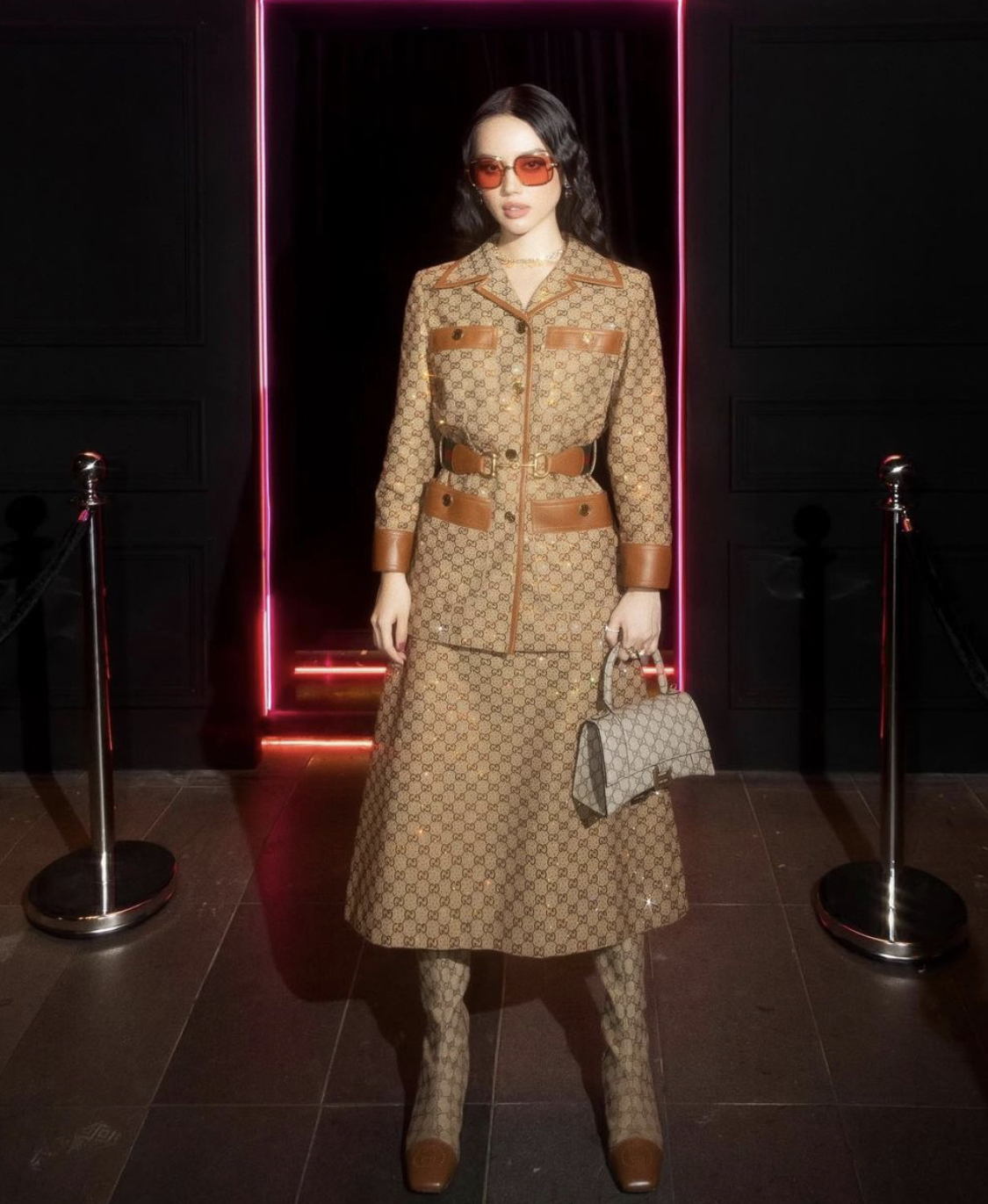 'Cô Em Trendy' Khánh Linh diện set Gucci từ áo vest, chân váy, boots cao cổ và túi xách đều phủ kín hoạ tiết 'GG'.