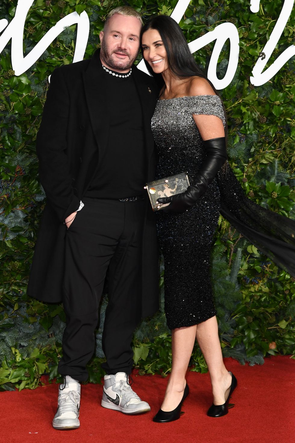Giám đốc sáng tạo Fendi - Kim Jones hộ tống siêu mẫu Demi Moore trong chiếc váy trễ vai, đính pha lê sang trọng.