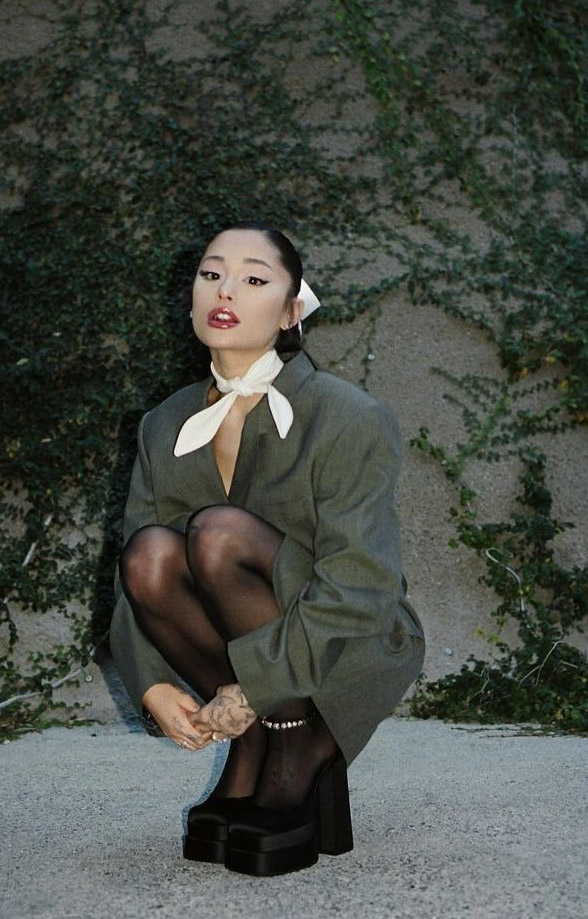 Trong ảnh, Ariana Grande xuất hiện với chiếc áo blazer oversized phối cùng vớ da và giày búp bê cá tính.