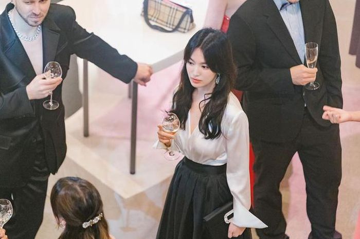 Kết hợp áo sơ mi lụa màu trắng với chân váy đen, Song Hye Kyo ghi điểm bởi sự nữ tính và sang trọng. 