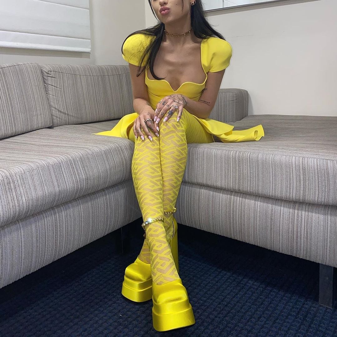 Ăn mừng hết dịch, Ariana Grande diện ngay 'cây vàng' chói chang của Versace. Set đồ gồm có đầm mini xòe, tất thêu hoạ tiết và đặc biệt là đôi giày đế xuồng cao 30cm.