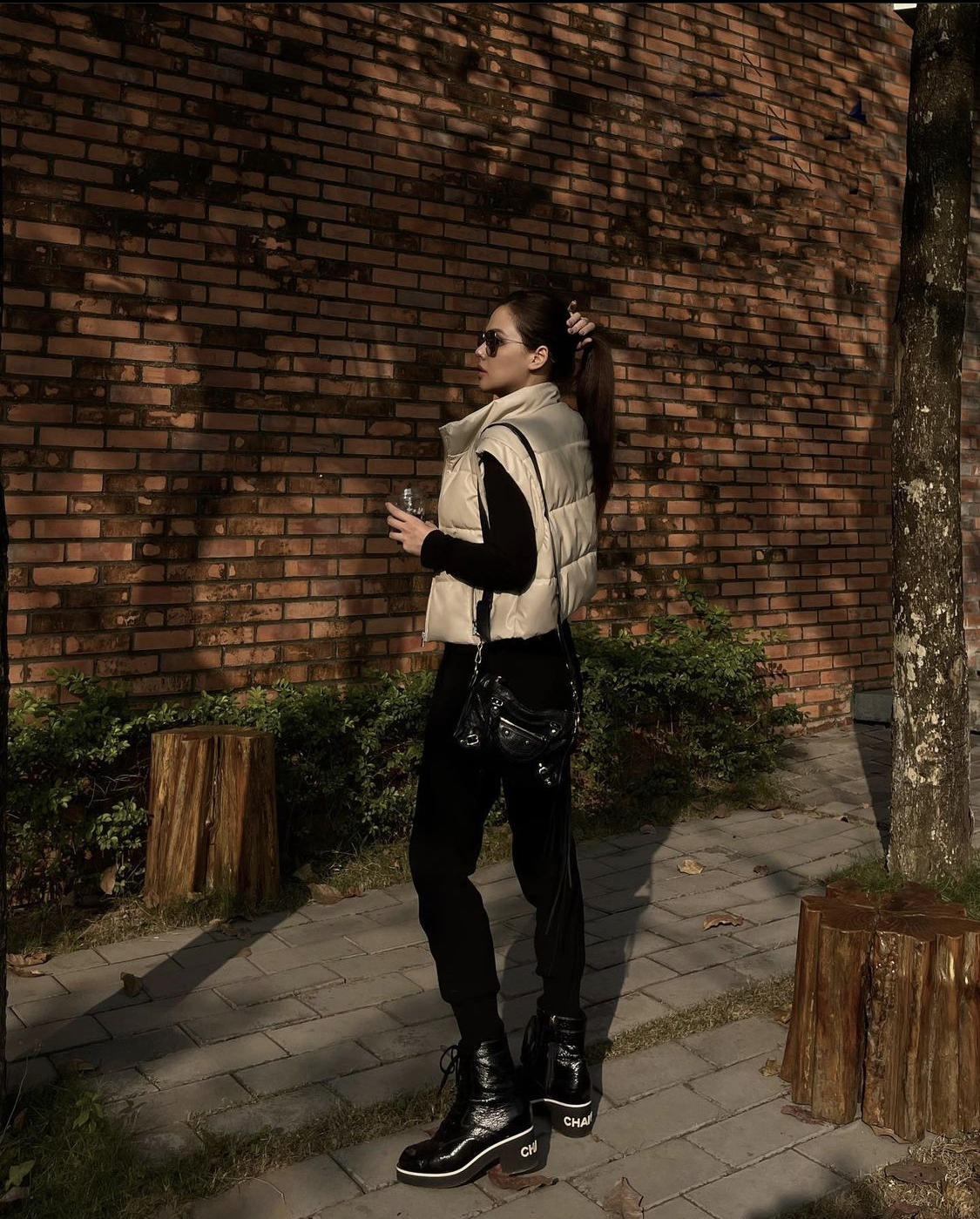 Thả dáng trên phố với trang phục cá tính, bodysuit đen kết hợp với áo phao trắng và boots Chanel sang chảnh, Phanh Lee trẻ trung, tràn đầy sức sống.