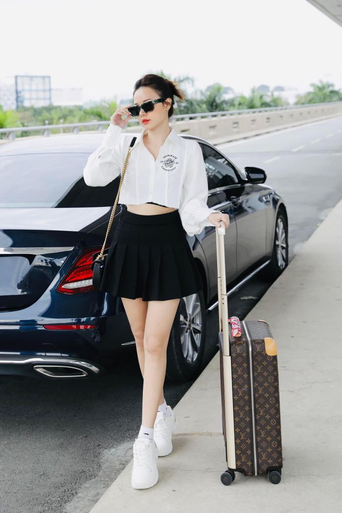 Màu trắng cứ đi với màu đen là hợp, nữ diễn viên năng động, trẻ trung với áo sơ mi trắng kết hợp chân váy ngắn đen, giày sneakers khi đi sân bay.