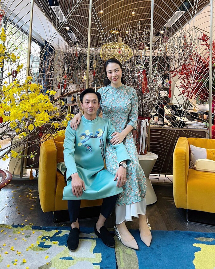 Cường Đô La và Đàm Thu Trang diện áo dài tone xanh biển, anh đơn giản với cành hoa trước ngực, nhường 'spotlight' cho vợ với cả một rừng hoa trên áo. 