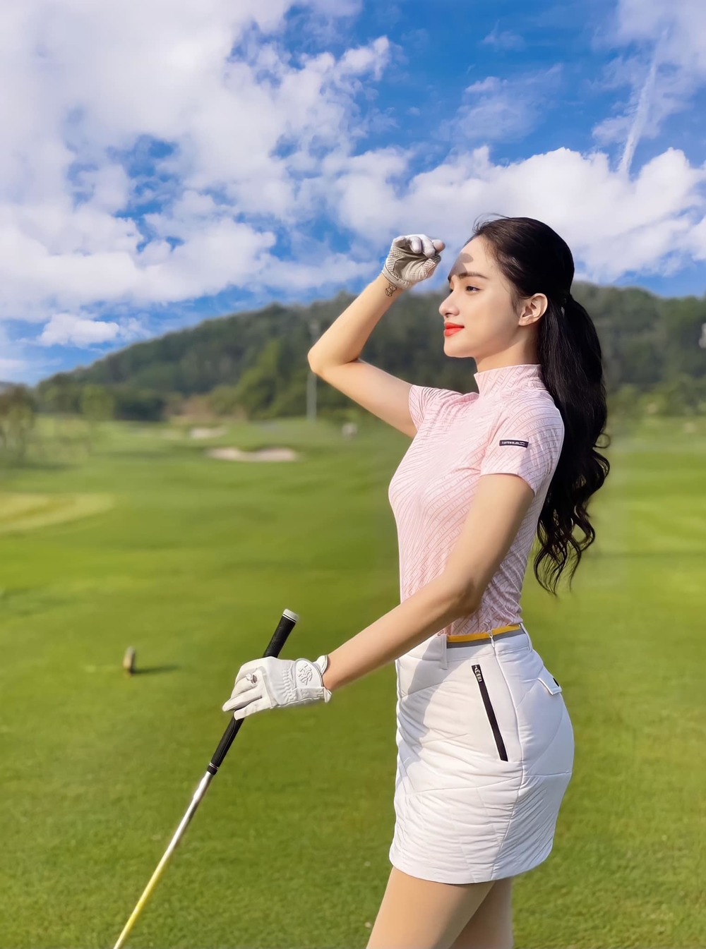 Mỹ nhân khoe dáng nuột nà trong set đồ thể thao sân golf tiêu chuẩn: áo polo, chân váy ngắn.