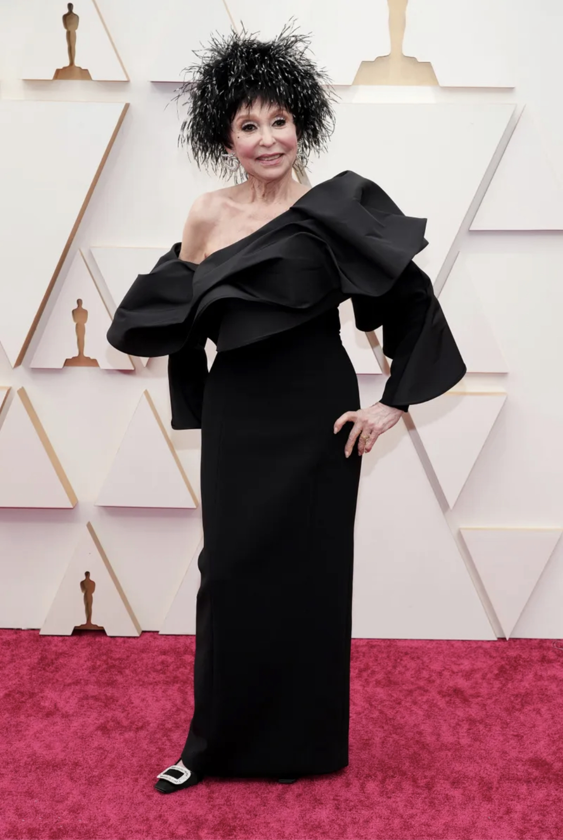 Nữ nghệ sĩ gạo rội Rita Moreno chỉ nên diện chiếc váy lệch vai xinh đẹp kia mà không nên phối cùng chiếc mũ lông kim tuyến lù xù ở trên đầu.