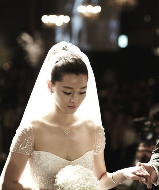 'Mợ chảnh' Jun Ji Hyun cũng chọn kiểu tóc búi cao cùng khăn voan trong ngày cưới. Mái tóc gọn gàng đã giúp nữ diễn viên khoe trọn vùng vai thanh thoát và chiếc cổ cao đắt giá.