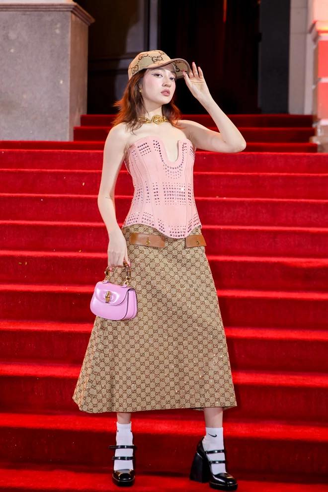 Bảo Anh diện corset hồng kết hợp chân váy, giày đế xuồng và điểm nhấn phụ kiện là túi Gucci Bamboo Mini màu hồng barbie xinh xắn.