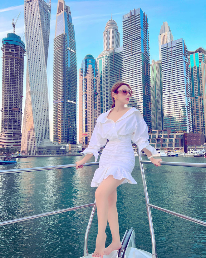 Huyền Baby diện áo sơ mi thả cúc cùng chân váy ôm sát quyến rũ trên mũi thuyền khi đi du ngoạn vịnh Marine Dubai.