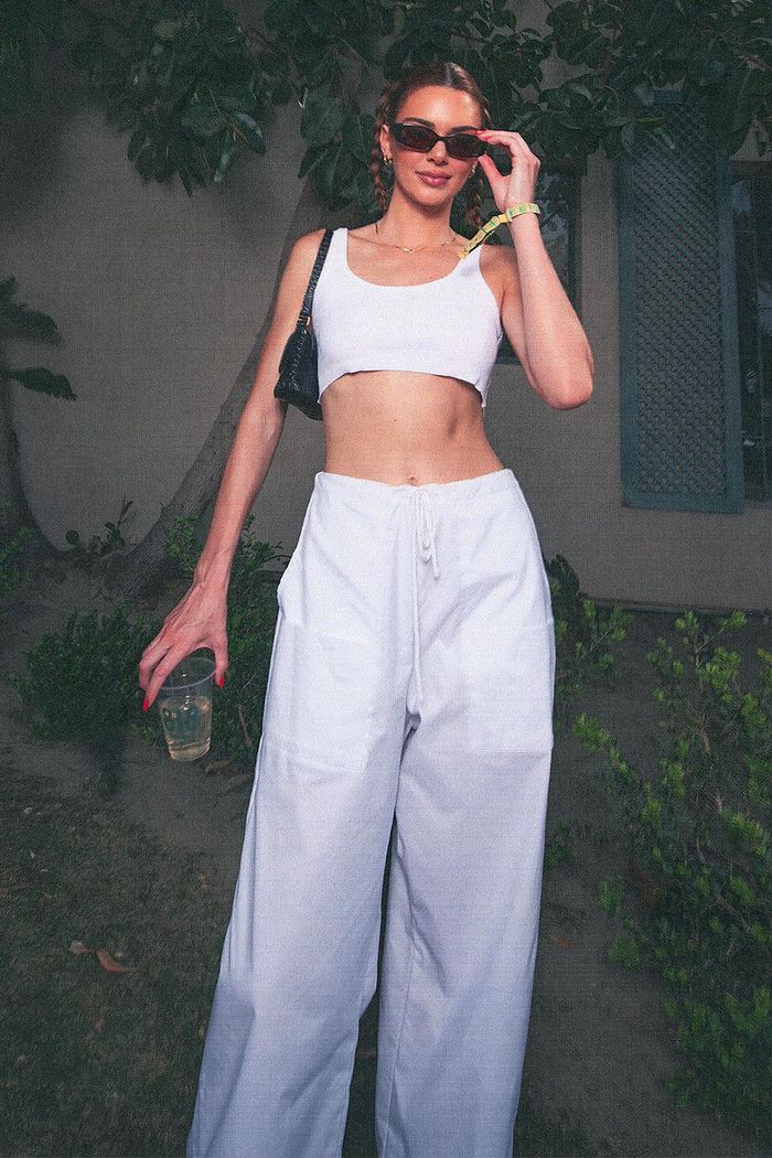 Kendall Jenner khoe dáng trong set đồ trắng đơn giản mà gợi cảm với áo croptop ngắn và quần suông.