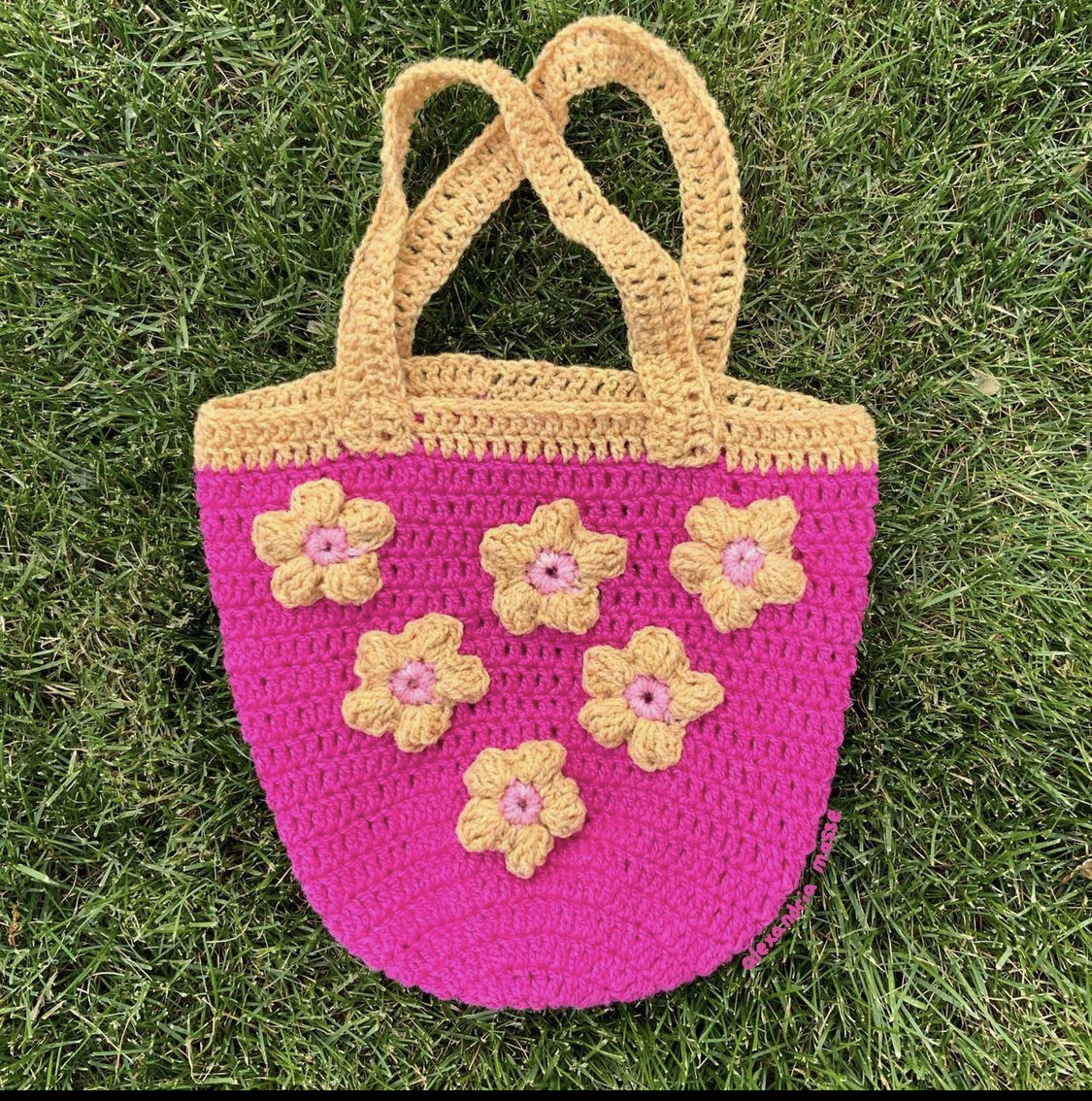 Túi xách đan len màu hồng nổi bật.