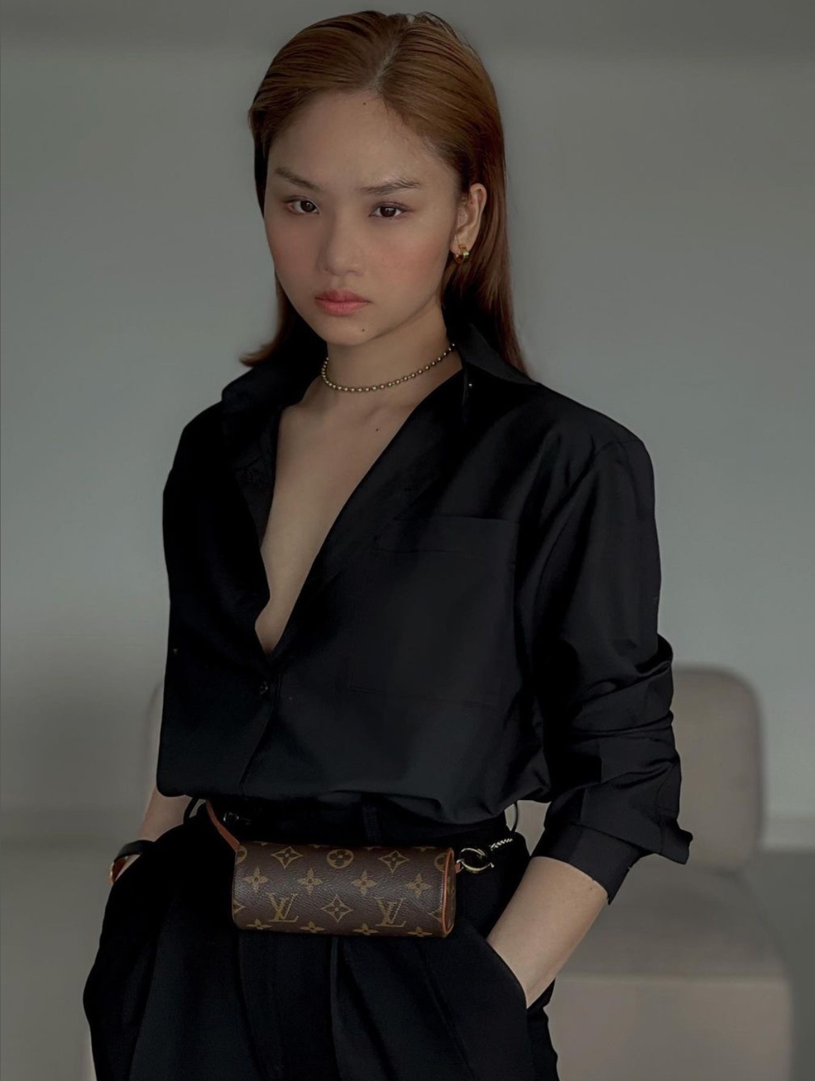 Kết hợp áo sơ mi và quần âu màu đen, Miu Lê tạo điểm nhấn bằng chiếc túi LV ở eo, giúp tỉ lệ cơ thể được cân đối hơn.