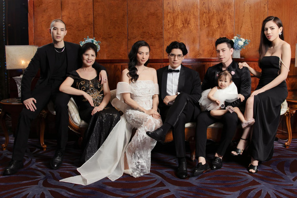 Hình ảnh của Ngô Thanh Vân và Huy Trần trong bộ ảnh gia đình, cô diện váy cưới đuôi cá trễ vai quyến rũ.