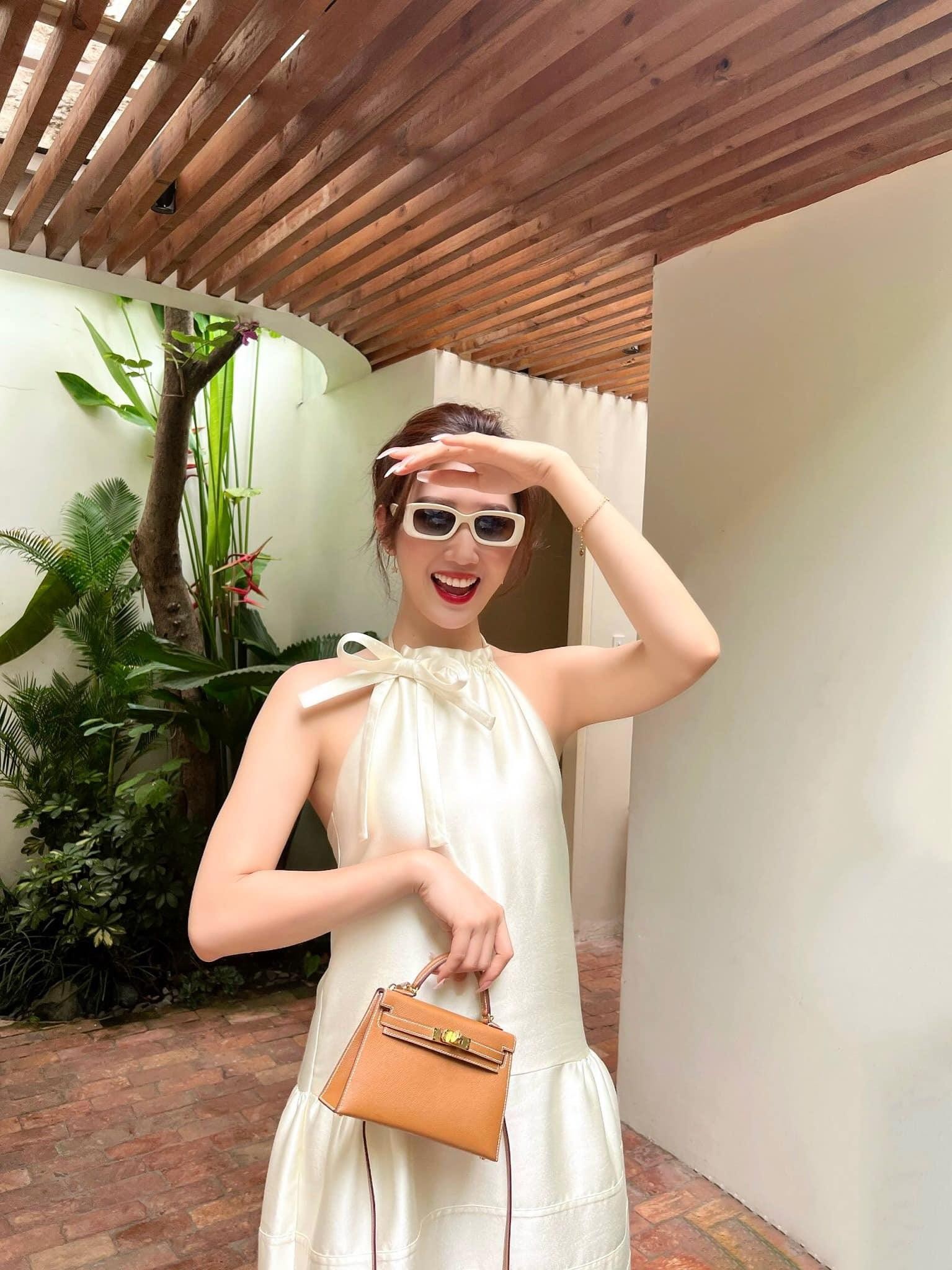 Thuỷ Ngân trong chiếc váy lụa, cổ yếm màu nude. Cô nàng kết hợp với túi xách Hermes Kelly mini, trông vừa sang vừa nữ tính.