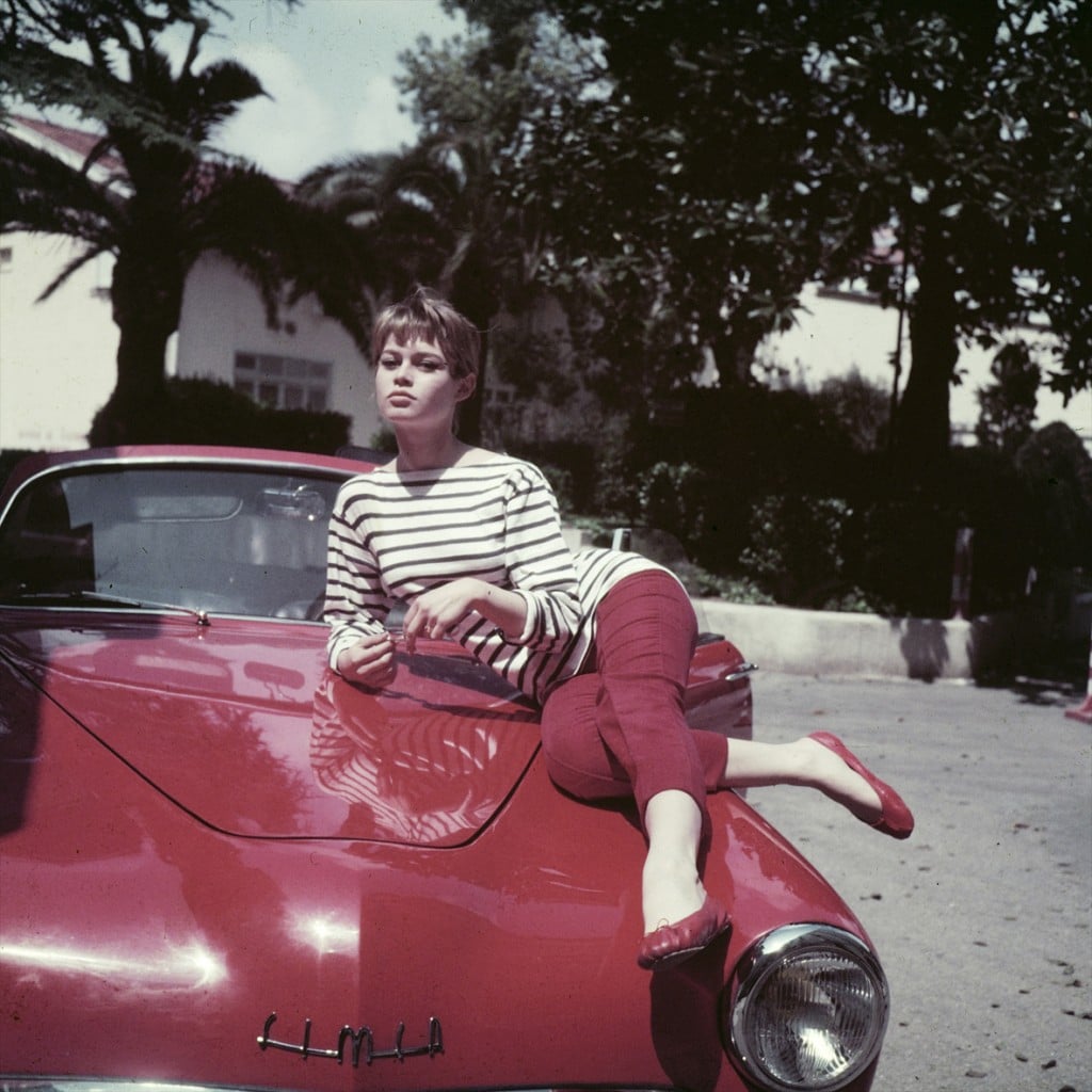 Brigitte Bardot khoe dáng trên chiếc xe hơi màu đỏ đồng điệu với quần và áo ba lê.