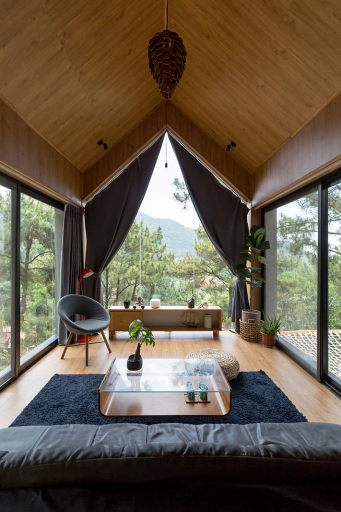 Hệ thống cửa kính bao quanh kết nối không gian trong nhà với thiên nhiên núi rừng xung quanh.