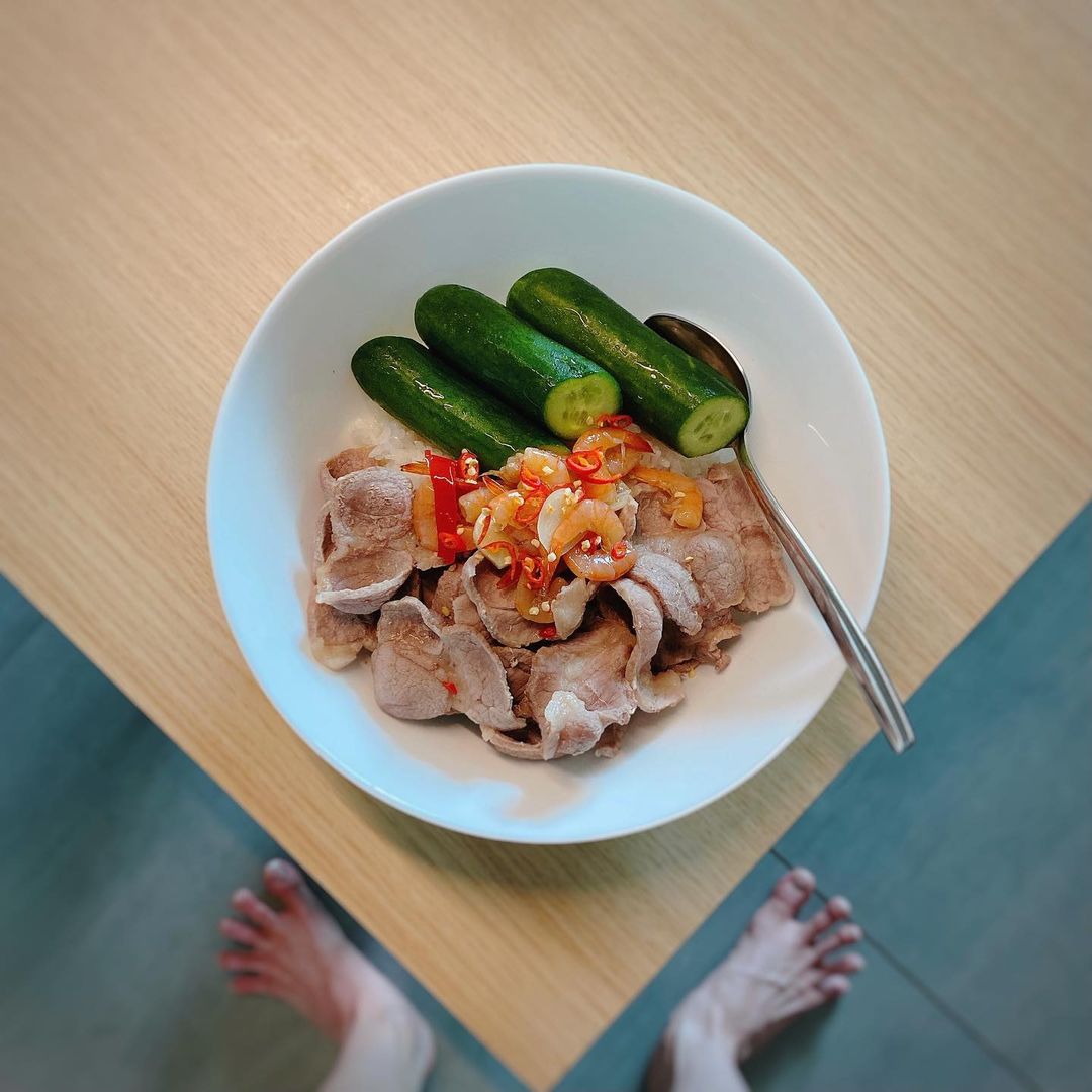 Bữa cơm với thịt luộc, dưa leo và tôm chua của Quang Trung khá hấp dẫn, thế nhưng 'ngó' xuống mà xem chân anh chàng kìa.