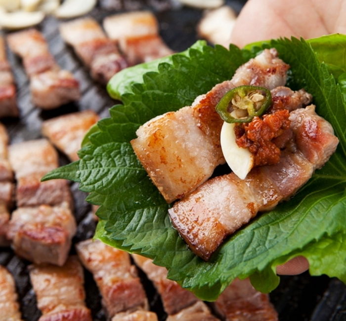 Người Hàn thường cuộn thịt cùng ớt, tỏi, tương ớt và rau sống.