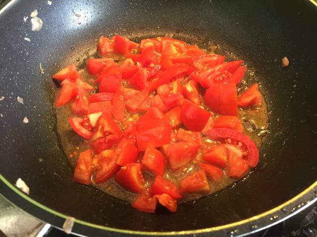 Khi hành tím đã dậy mùi thì cho cà chua thái nhỏ vào xào mềm.