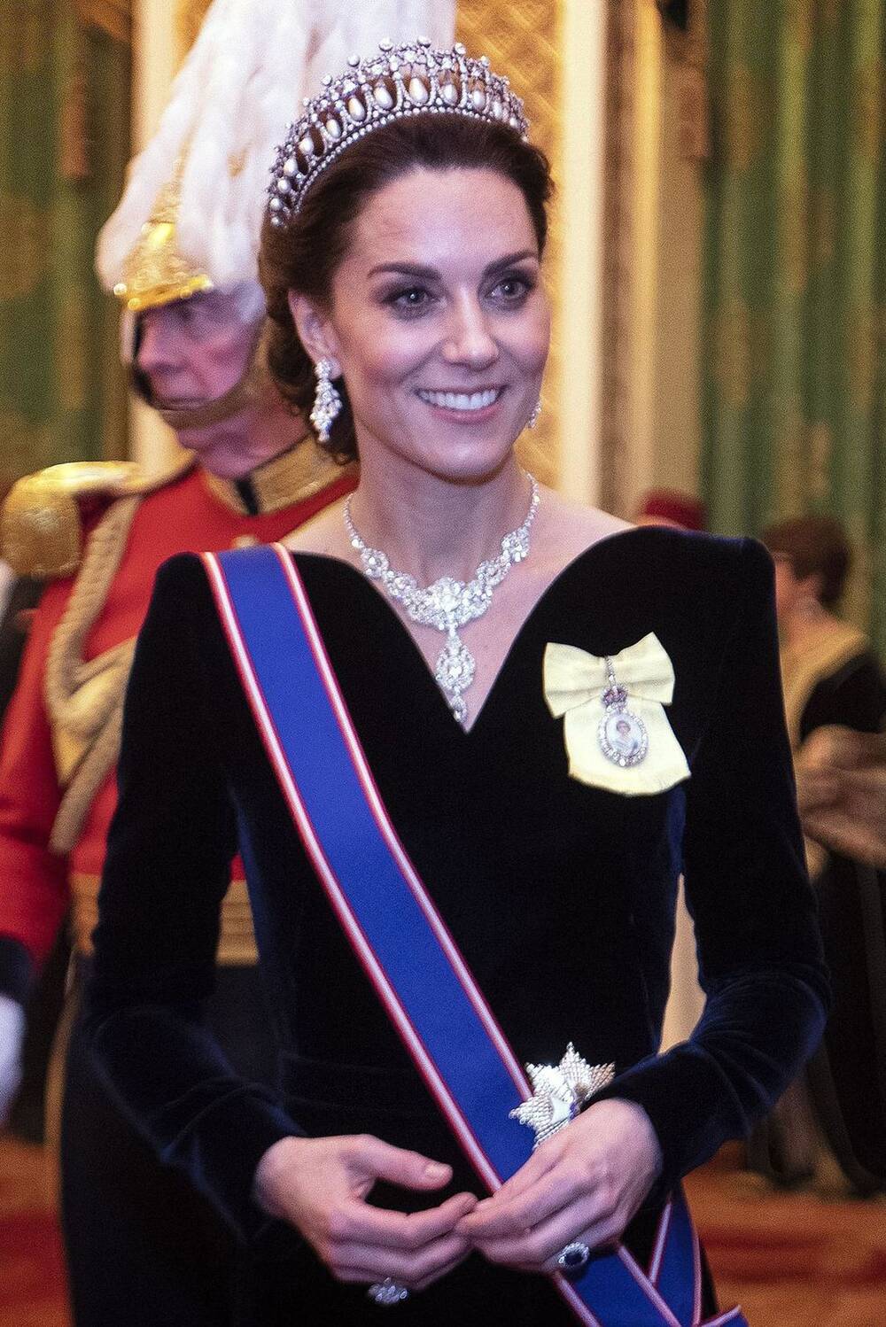 Tại một sự kiện tại cung điện Buckingham, Kate mặc một chiếc váy đen của Alexander McQueen. Cô đeo vòng cổ kim cương được thừa hưởng từ nữ hoàng Anh (bà nội chồng) và khuyên tai của mẹ chồng
