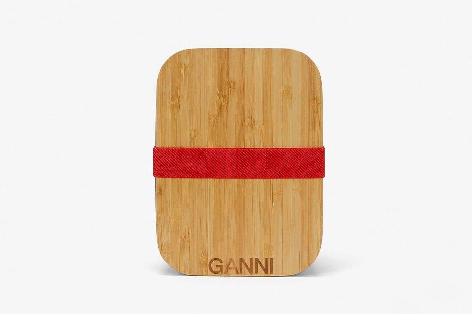 Một chiếc hộp bằng gỗ được đeo thêm một cọng dây thun màu đỏ và cộp thêm logo Ganni có giá 59 USD. Vì thế, hãy nâng niu nó bằng tất cả trái tim của mình.