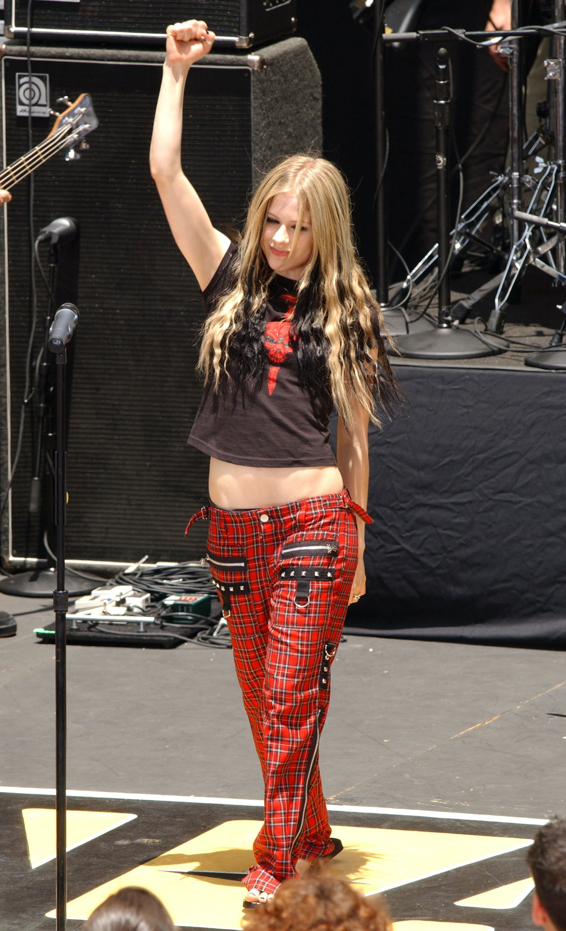 Avril Lavigne nổi bật chiếc quần vải tartan cạp trễ, kết hợp với áo phông hình đầu lâu và đôi dép tông. Lớp trang điểm nhấn vào đôi mắt đen của Avril vẫn không hề thay đổi sau nhiều năm.
