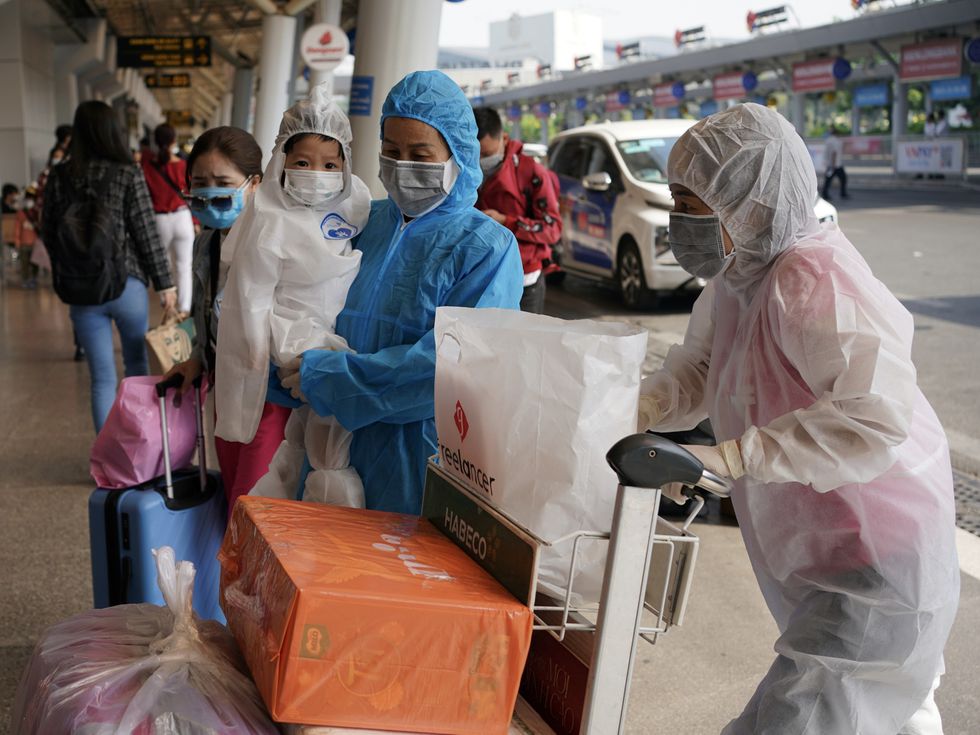 Hình ảnh người mặc áo bảo hộ, trùm kín mít không còn xa lạ tại sân bay Tân Sơn Nhất. Ảnh: Báo Thanh niên