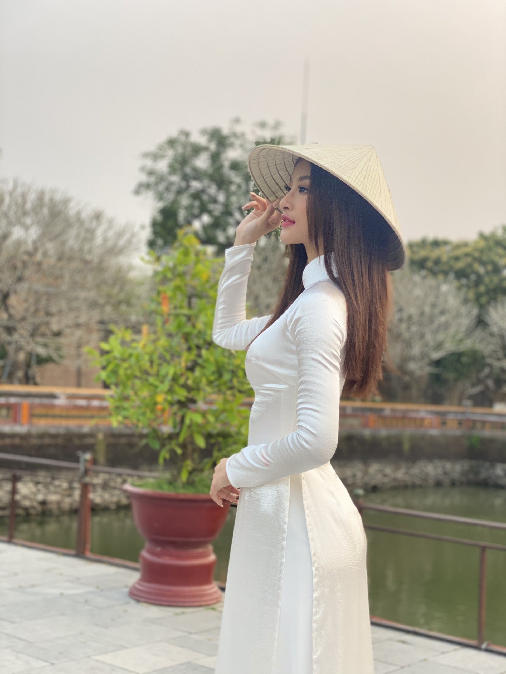 Lấy bối cảnh chùa Thiên Mụ, Á hậu Kiều Loan khéo léo diện áo dài trắng kín đáo, phù hợp với khung cảnh linh thiêng. Cô kết hợp biểu tượng truyền thống của Việt Nam và chiếc nón lá đặc trưng để mang đến hình ảnh thuần Việt.