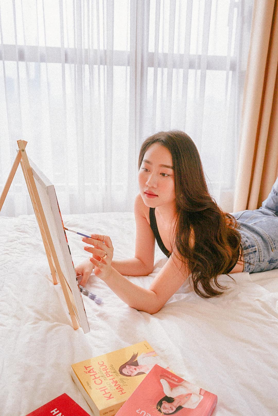 Huỳnh Hồng Loan tận hưởng những ngày giãn cách thảnh thơi tại nhà. Cô chia sẻ hình ảnh vẽ tranh trên giường ngủ cùng nhiều cuốn sách đọc thư giãn.