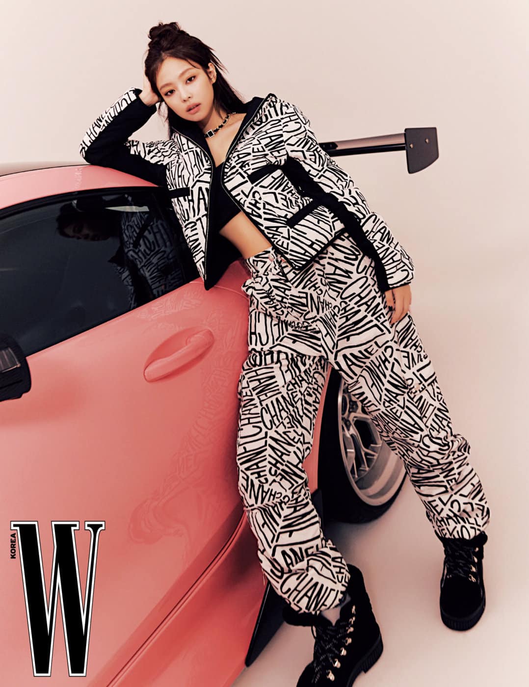 Jennie cá tính với crop-top đen kết hợp set áo khoác và quần bằng vải canvas họa tiết tên thương hiệu, dây chuyền và giày đều của Chanel.