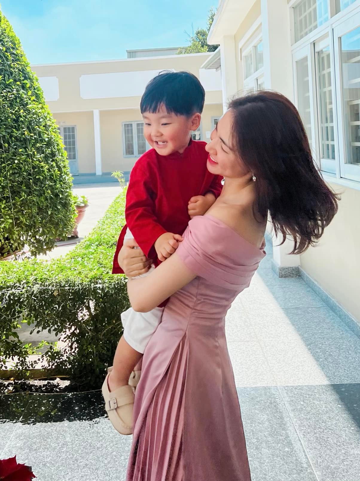 Trong thời tiết nắng ấm của Sài Gòn, Hòa Minzy chọn váy hồng trễ vai vào ngày mùng 1 Tết. Cô diện cho con trai Bo bộ áo dài đỏ rực rỡ và ngọt ngào bày tỏ: 'Năm mới cho Hoà Minzy xin được chúc tất cả mọi người luôn bình an và hạnh phúc'.