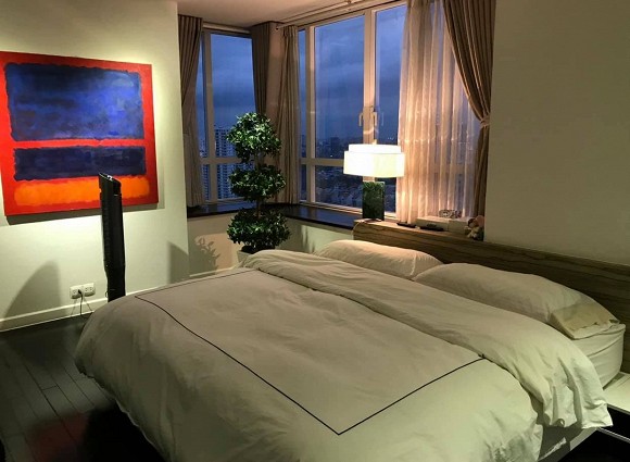 Phòng ngủ được trang trí hệ thống đèn vàng dịu trên nền tông trắng chủ đạo, tạo không gian riêng tư ấm áp, thư thái.