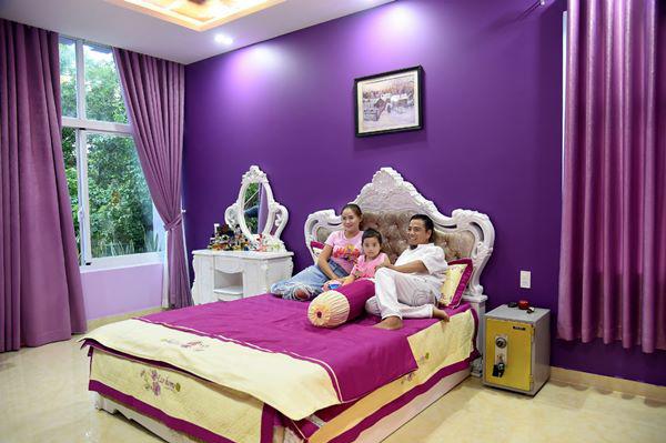 Không gian phòng ngủ ngập tràn sắc tím có điểm nhấn là chiếc giường và bàn trang điểm màu trắng nổi bật.