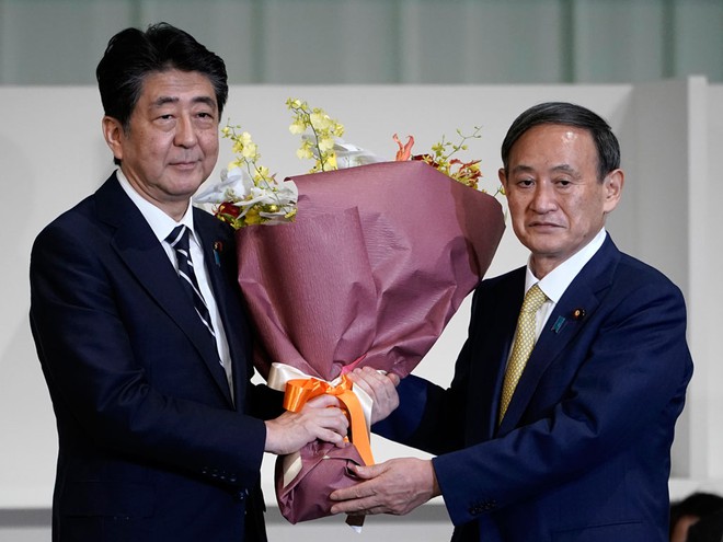 Tân Thủ tướng Nhật Bản Yoshihide Suga nhận hoa chúc mừng từ người tiền nhiệm Shinzo Abe.