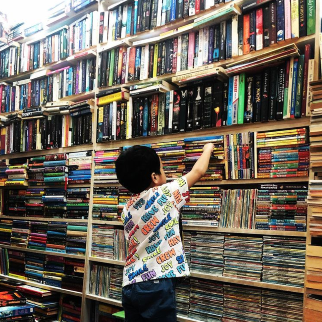 Hình ảnh con trai Tăng Thanh Hà chọn sách tại 1 hiệu sách ở Singapore