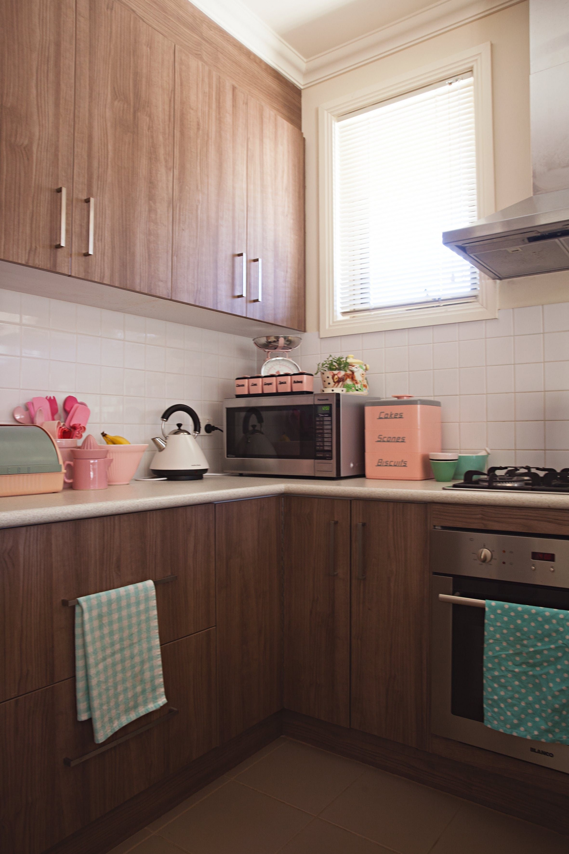 Bếp dù được ốp gỗ nhưng vẫn có thêm những đồ trang trí màu hồng. Đây vừa là điểm nhấn, vừa tạo sự thống nhất về phong cách trong nhà.