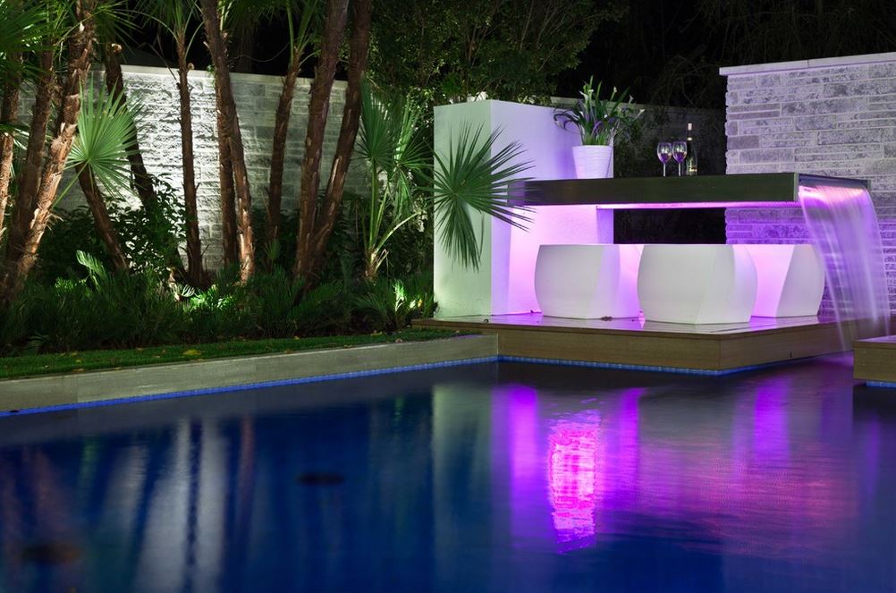 Không hề sử dụng đèn lắp cho bể bơi, nhưng khu vực quầy bar bên cạnh bể bơi lại được lắp đèn LED khiến cho khi nước chảy qua bên dưới gầm quầy phát sáng hắt xuống bể bơi tạo nên gam màu tuyệt đẹp.