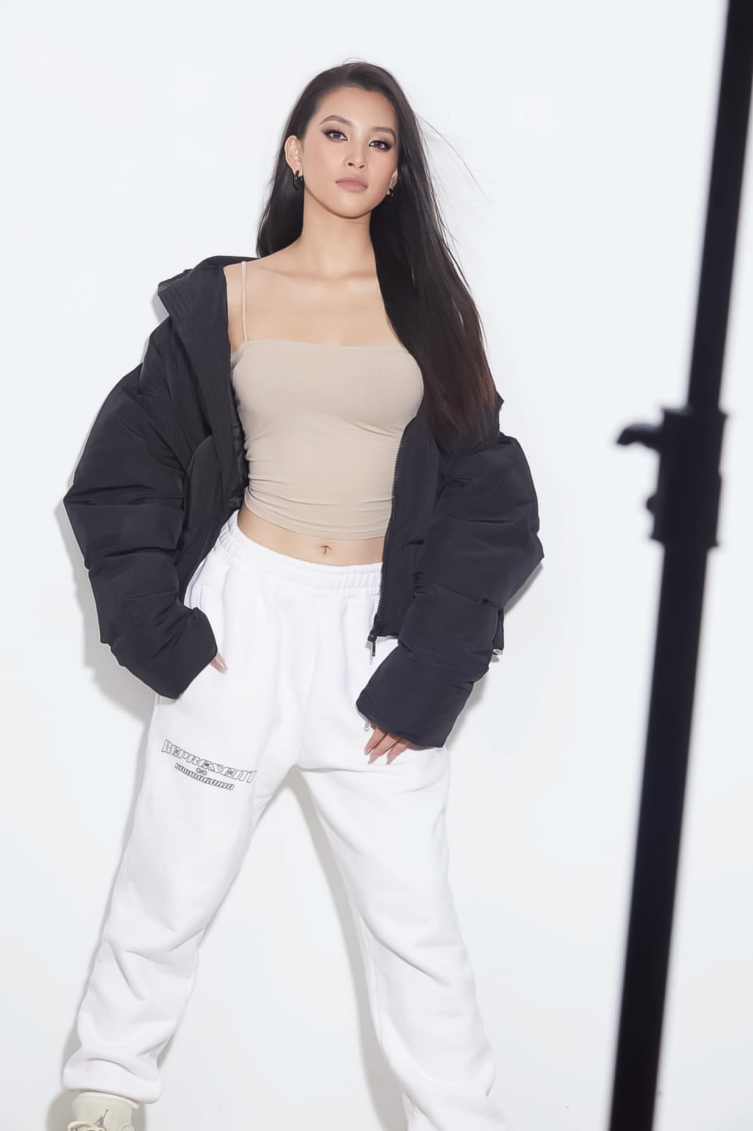 Với bộ ảnh cá tính 'cool ngầu', Tiểu Vy vẫn giữ nét đẹp quyến rũ với trang phục đậm style hip hop khi mix áo bomber jacket , quần jogger trắng.